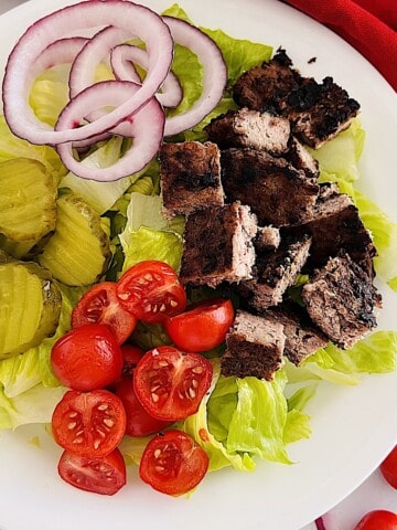 Healthy Burger Bowl with diced beef patty, lettuce, pickles, onion, & tomatoes.