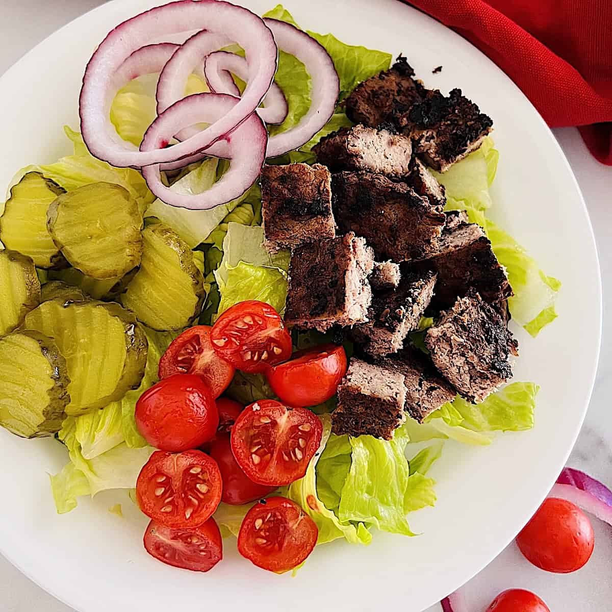 Healthy Burger Bowl with diced beef patty, lettuce, pickles, onion, & tomatoes.