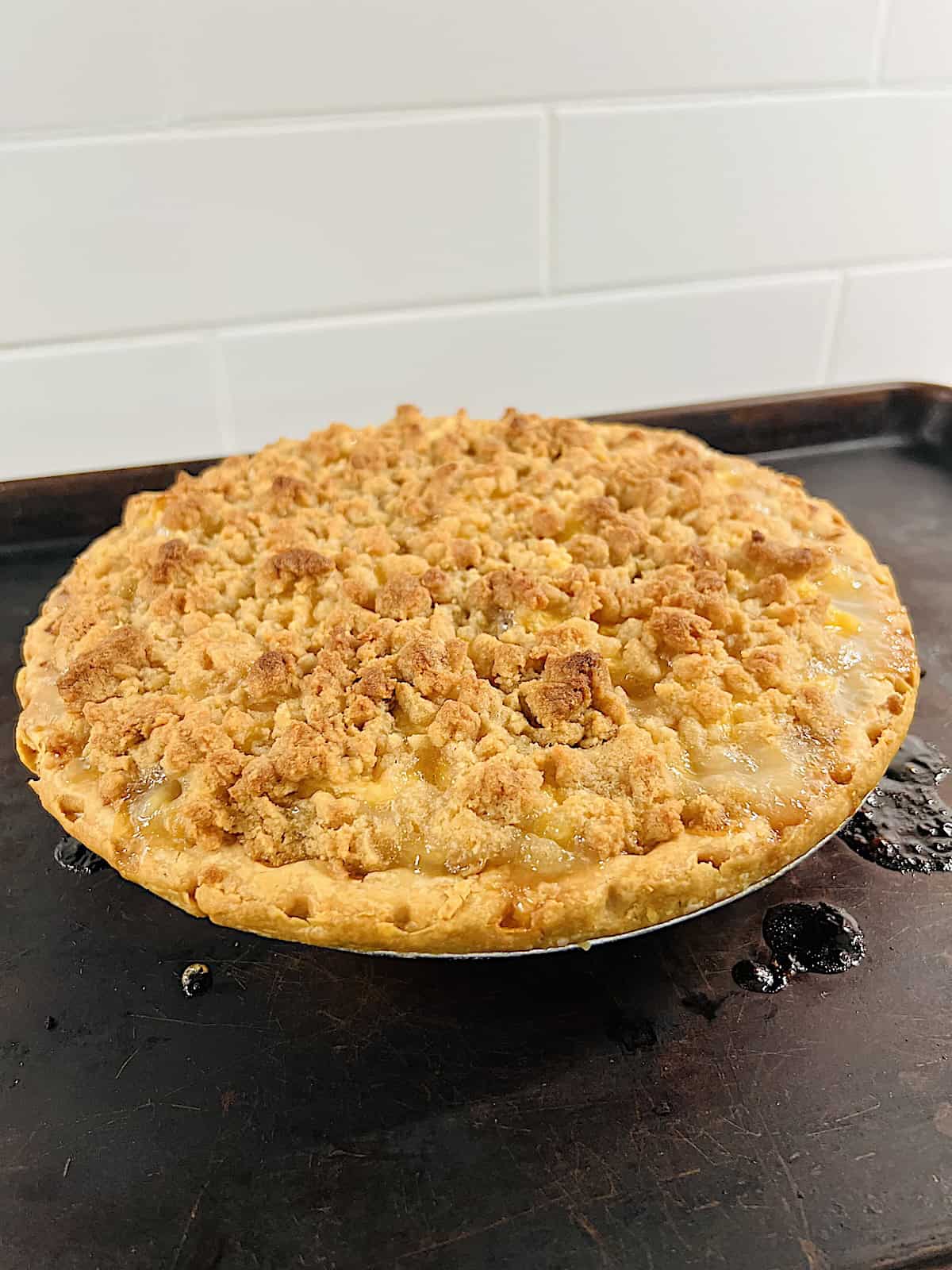 Peach Crumble Pie Baked and resting on baking sheet to cool.