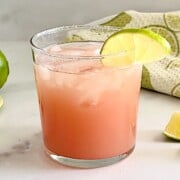 Glass of guavarita, a pink guava margarita with a salted rim served over ice.