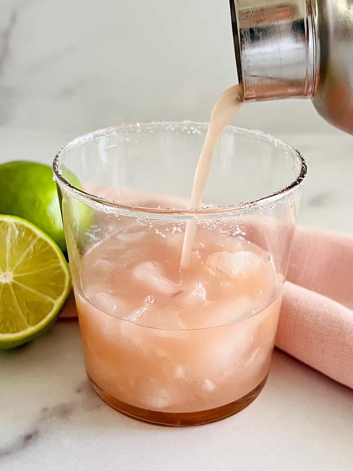 Guava Margarita Pouring cocktail through shaker into salted glass.