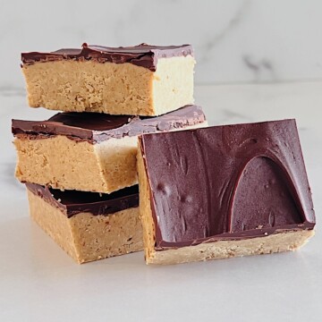 No Bake Chocolate Peanut Butter Bars cut into squares stacked on the counter.