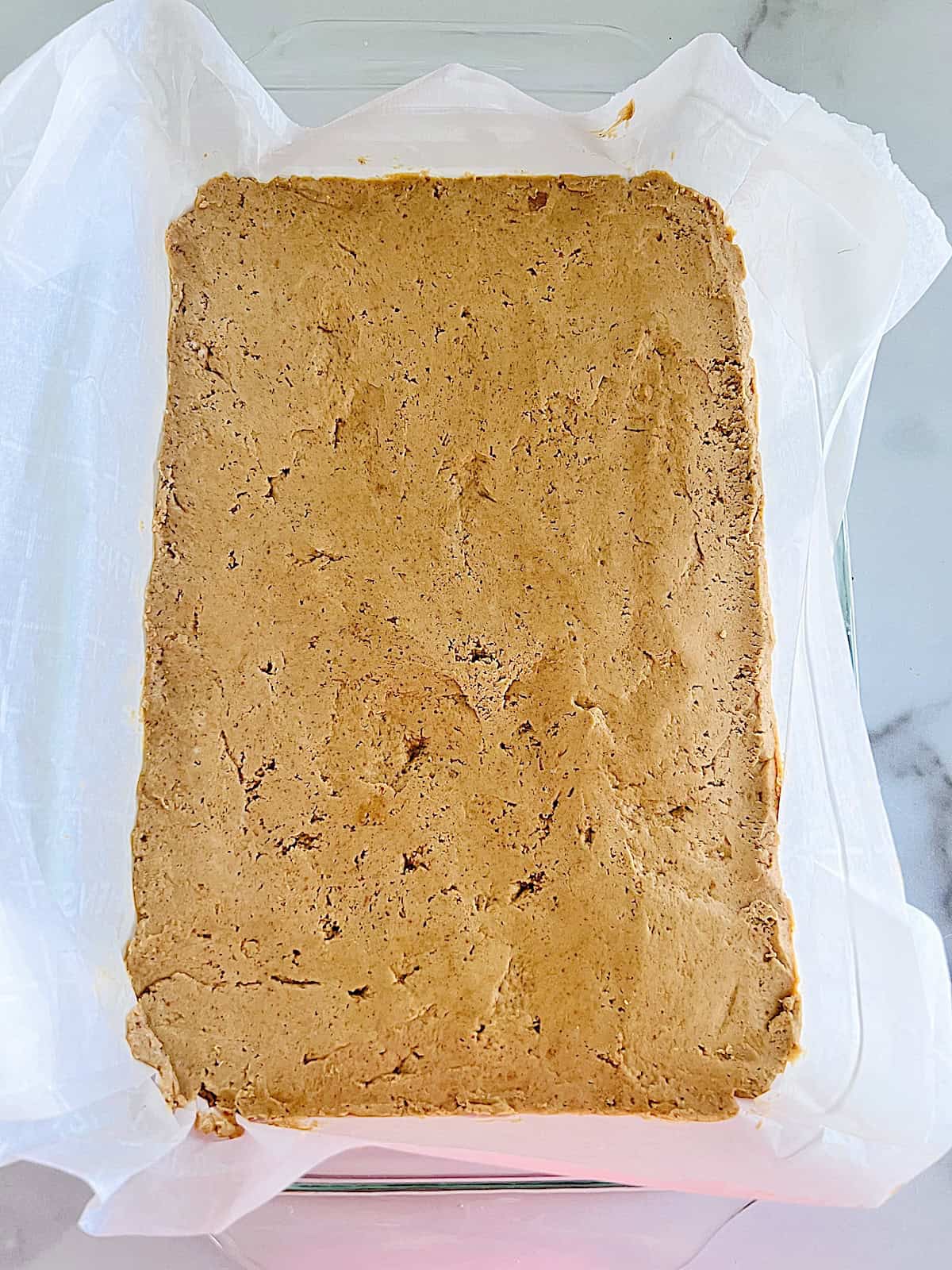 No Bake Chocolate Peanut Butter Bars Parchment lined glass 7x12 pan with pb layer