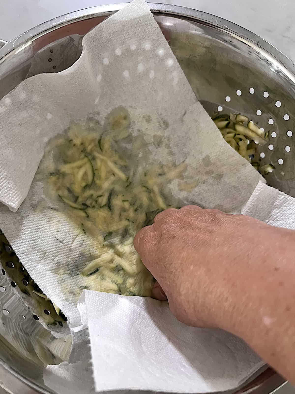 Pressing zucchini to remove moisture.
