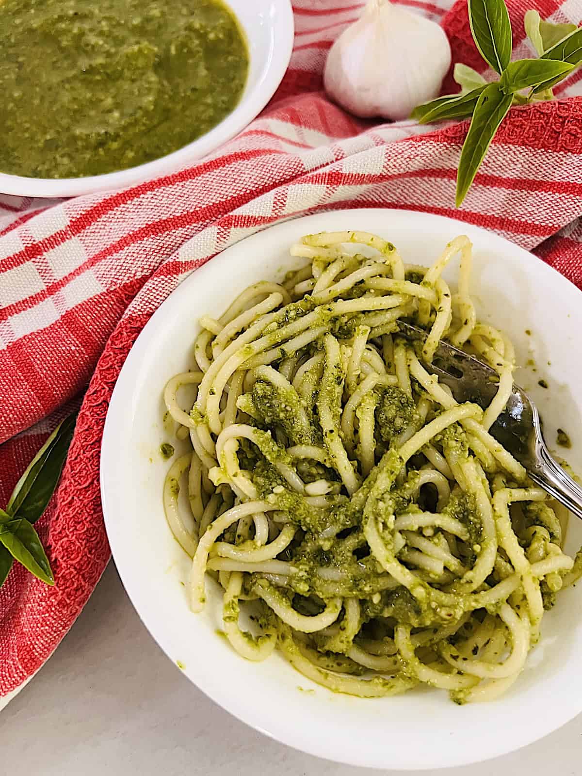 Basil Pesto Sauce (Pesto alla Genovese) Served over spaghetti in a bowl.