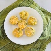 Plate with mini egg bites fresh baked and ready to eat with cheese, ham, & onions.