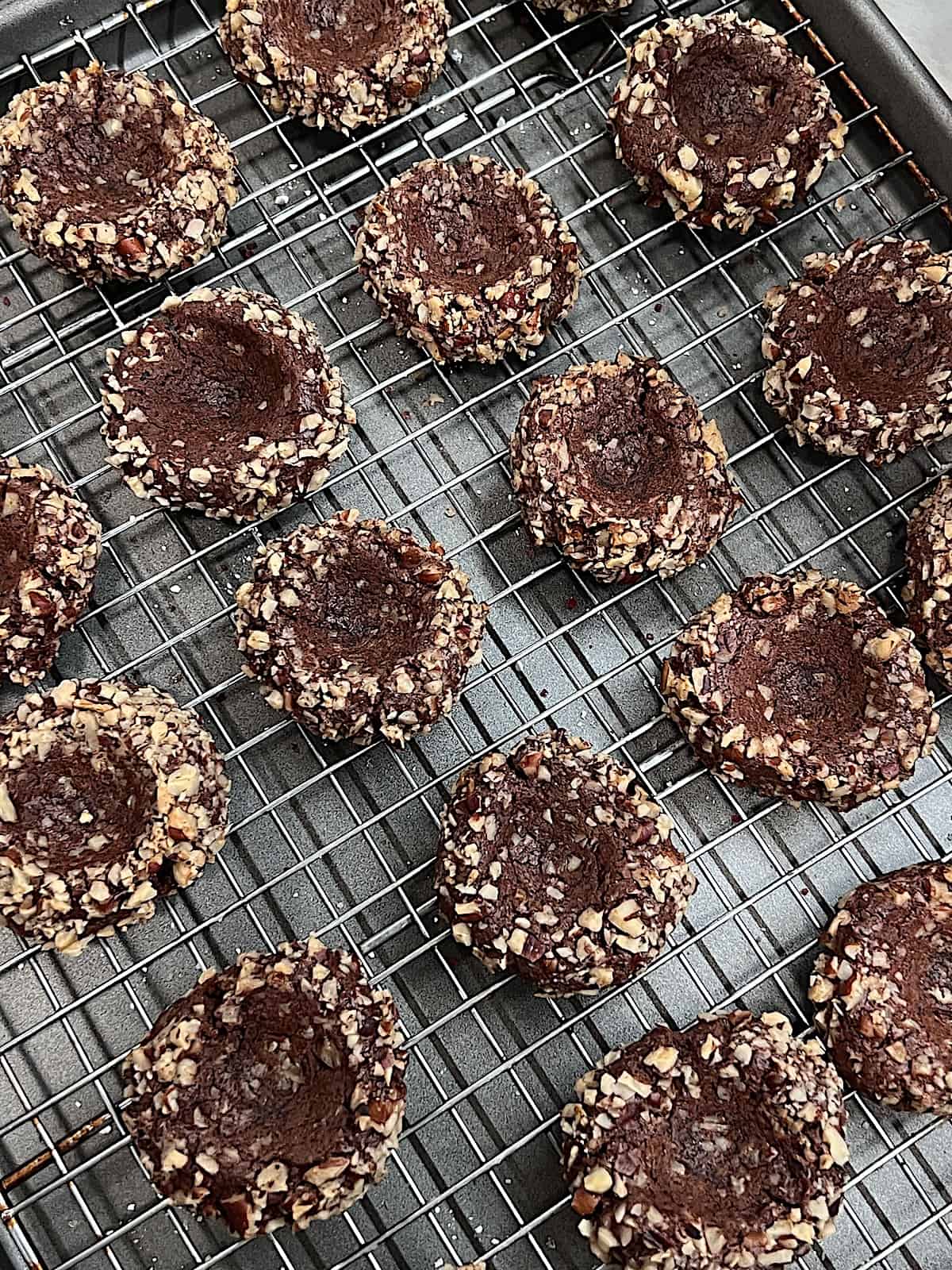 Turtle Thumbprint Cookies Baked chocolate cookies rolled in pecans with indent thumbprint before adding caramel.