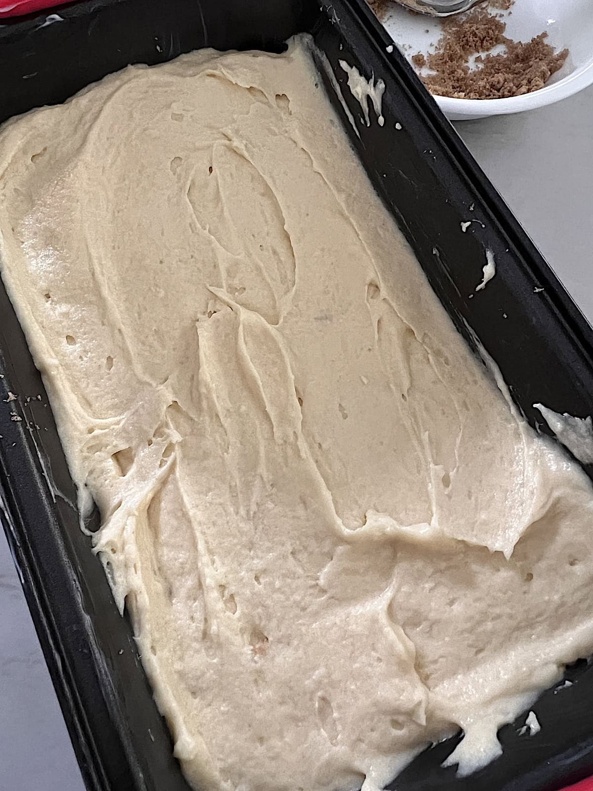 Loaf pan with cake batter at the bottom.
