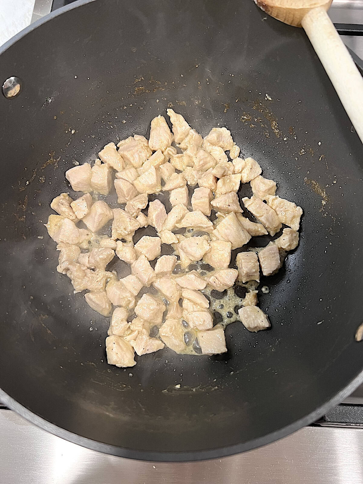 Chicken Broccoli Mac & Cheese Cooked chunks of chicken in a pot.