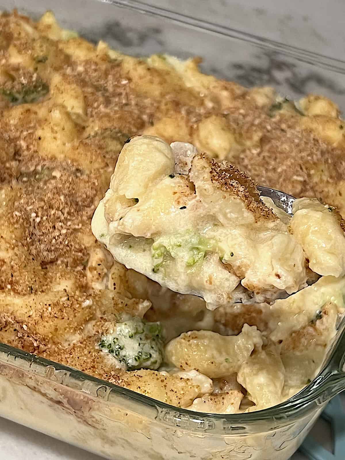 Chicken Broccoli Mac & Cheese Spoon serving out of the casserole dish.
