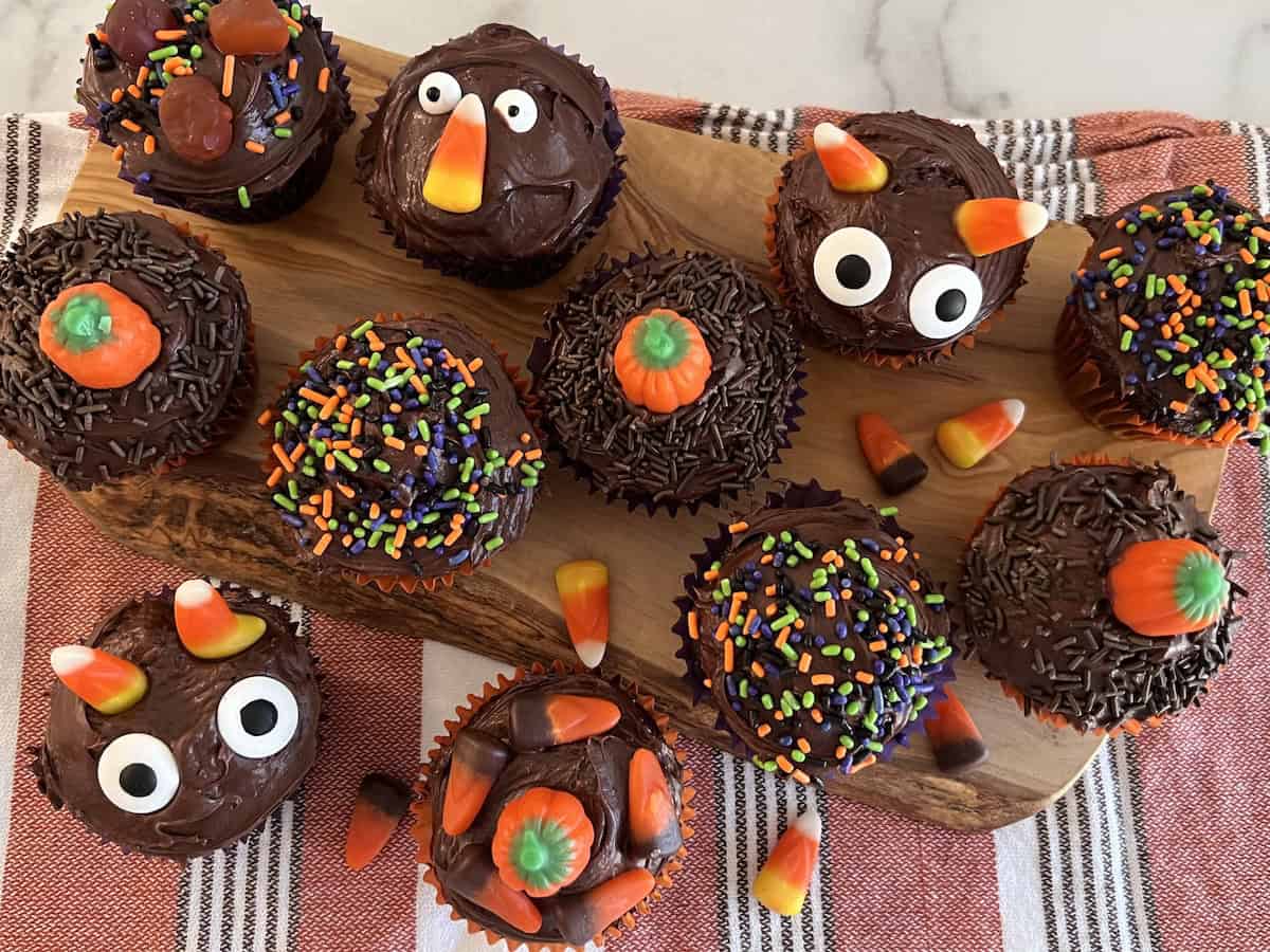 Easy recipe for Halloween Cupcakes from boxed cake mix with chocolate frosting and decorated with sprinkles, candy corn and candy eyes.